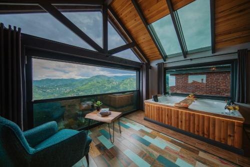 a bathroom with a tub and a large window at Lazivilla Suit Dağ Evi in Rize