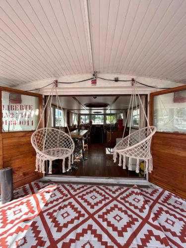 une chambre avec deux chaises, un lit et un tapis dans l'établissement Péniche Design 115m2 Port Privé Vue Seine à 15min de Paris, à Asnières-sur-Seine