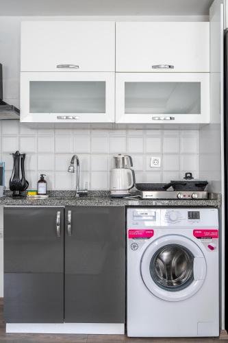 a kitchen with a washing machine and a sink at Sorta Hotel in Antalya