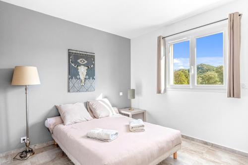 une chambre blanche avec un lit et une fenêtre dans l'établissement Villa Mara, à Lecci