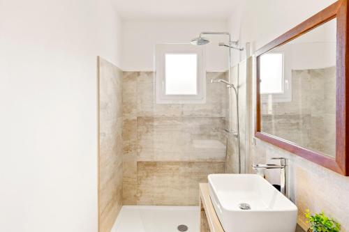 une salle de bain blanche avec un lavabo et une douche dans l'établissement Villa Mara, à Lecci