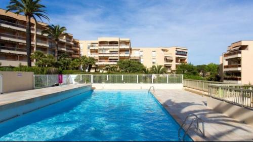 une piscine au milieu d'un immeuble dans l'établissement Appartement Angela, au Golfe-Juan