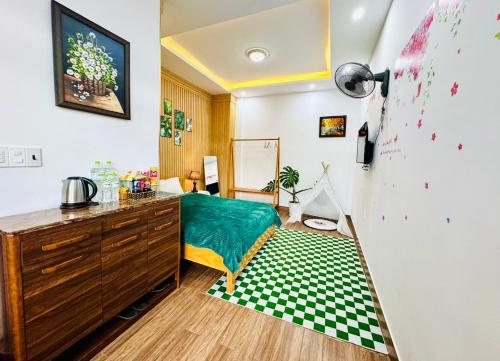 a bedroom with a bed and a dresser with a green sheet at Pine Forest House Dalat in Xuan An