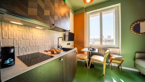 une cuisine avec un comptoir et une table avec des chaises dans l'établissement La Chambre 608 - studio cosy centre ville proche port embarcadère, à Toulon