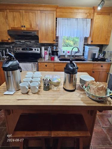 a kitchen with a wooden table with pots and cups at Small Town Bound Inn in Montague