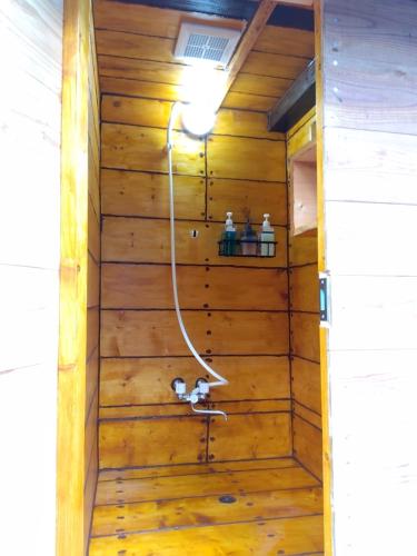 a sauna with a hose in a wooden wall at ＰＥＮＳＩＯＮ　ＳＨＩＭＡＫＡＺＥ in Motobu