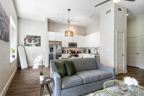 a living room with a couch and a kitchen at Tasteful Condo Walking Distance to French Quarter in New Orleans