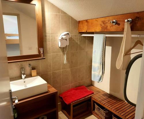 - une petite salle de bains avec lavabo et tabouret rouge dans l'établissement Isola 2000 duplex 7P vue pistes dernier etage, à Isola 2000