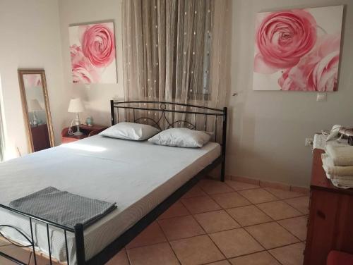 a bedroom with a bed with pink roses on the wall at Studio eva in Palouki