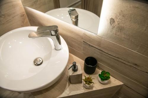 a bathroom with a white sink and a mirror at SKIA luxury living above the walls in Thessaloniki