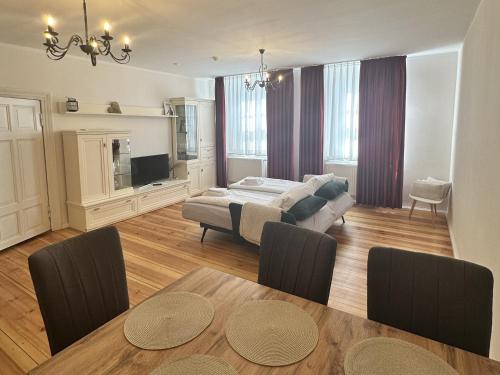 a living room with a bed and a dining table at Apartmenthaus Gutenberg 78 in Potsdam