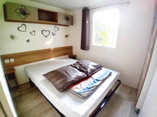 un petit lit dans une chambre avec une fenêtre dans l'établissement Mobil home 3 chambres, à Saint-Jean-de-Monts