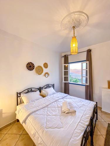 a bedroom with a large white bed with a window at Dar Bakkali Nadi in Tangier