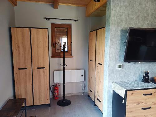 a room with wooden cabinets and a flat screen tv at Leśne Zacisze domki letniskowe in Lipnica