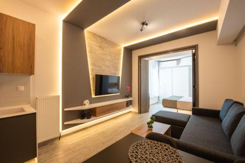 a living room with a couch and a tv at SKIA luxury living above the walls in Thessaloniki