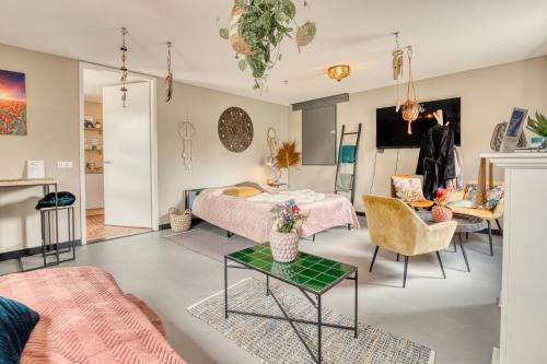 a living room with a bed and a table and chairs at Appartement YCW 'Papillon' in Rijnsaterwoude