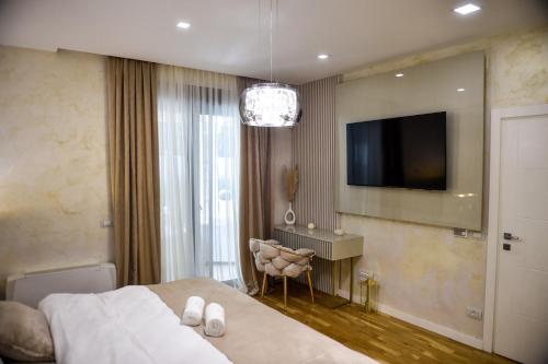 a bedroom with a bed and a flat screen tv at Villa Dolce Vita in Međugorje