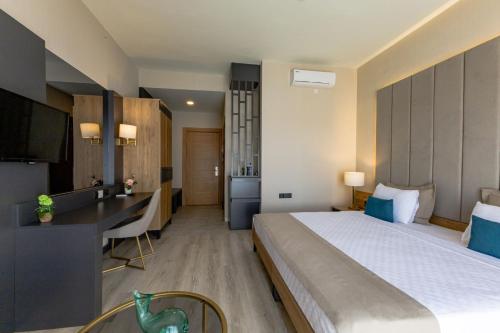 a hotel room with a large bed and a desk at PARADISOS HOTEl in Trakhoni