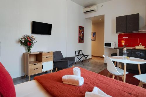 a living room with a red bed and a kitchen at Aparthotel AMMI Nice Massena - ex Ajoupa in Nice