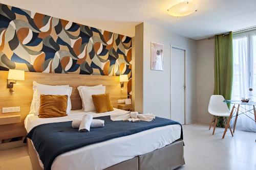 a bedroom with a large bed with a wall at Aparthotel AMMI Nice Massena - ex Ajoupa in Nice