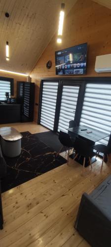 a living room with a table and a tv at Naujai įrengtas atostogų namelis in Anykščiai
