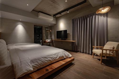a bedroom with a bed and a tv and a chair at 全村的希望Hope of village in Dongshan