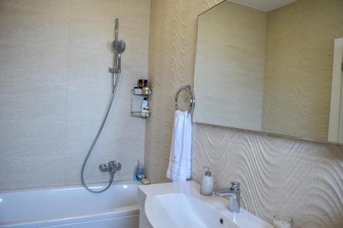 a bathroom with a sink and a mirror and a tub at Villa Dolce Vita in Međugorje