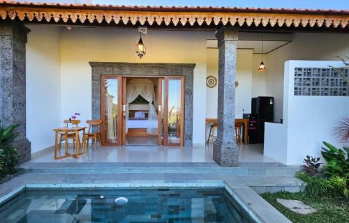 a villa with a swimming pool in front of a house at Weda Villas in Ubud