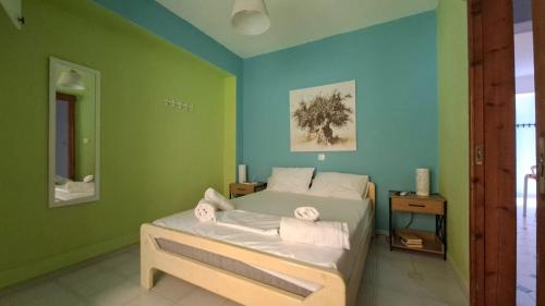 a bedroom with a bed with green and blue walls at Homico 2 Lefokastro in Lefokastro