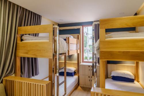 a room with three bunk beds and a window at เดอะซีน คาบาน่า บีช รีสอร์ท ขนอม The Scene Cabana Beach Resort Khanom in Ban Plau