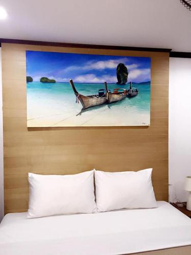 a bedroom with a bed with a painting on the wall at Baan Ketkeaw Guest House 2 in Patong Beach