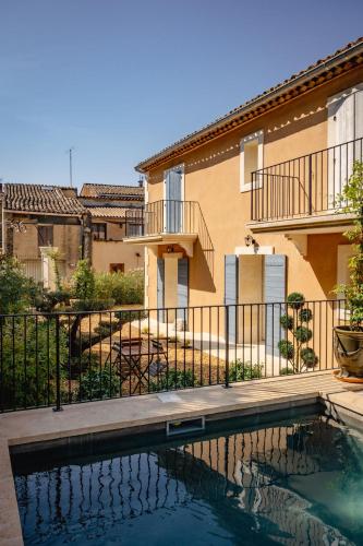 une maison avec piscine devant un immeuble dans l'établissement Le mas de Roussillon chambre d'hôtes, à Roussillon