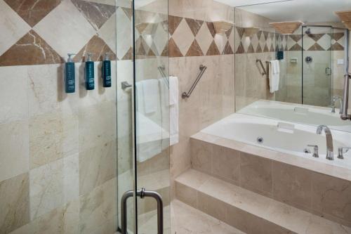 a bathroom with a shower and a tub and a sink at Hilton Chicago/Northbrook in Northbrook