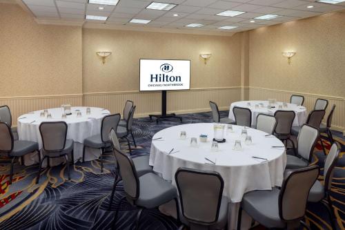 a conference room with white tables and chairs and a sign at Hilton Chicago/Northbrook in Northbrook