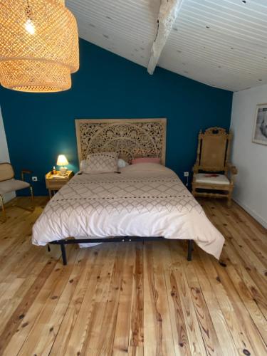 a bedroom with a bed and a blue wall at Appartement du sud in Saint-André-de-Sangonis