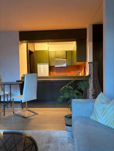 a living room with a couch and a kitchen at Wohnung in den Bergen - 1 Stunde von Zürich in Filzbach