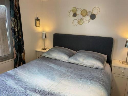 a bedroom with a bed with two pillows on it at Tiny house met tuin en 2 fietsen in Putten op de Veluwe in Putten