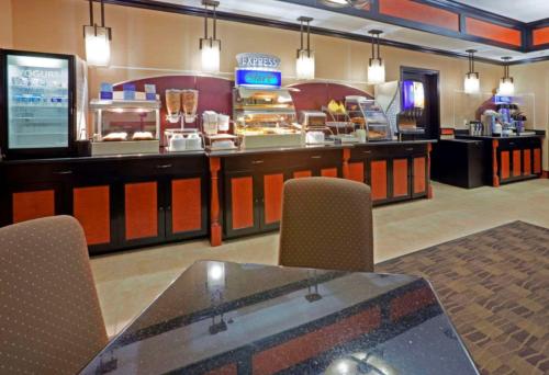 Un restaurante con una mesa y sillas y un mostrador de comida. en Comfort Inn & Suites Dallas Medical-Market Center, en Dallas