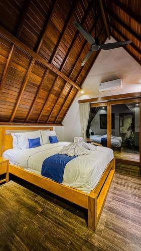 a bedroom with a large bed with a ceiling at Villa Tegal lovina in Buleleng