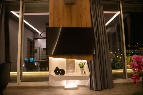a living room with a tv on top of a fireplace at SKIA luxury living above the walls in Thessaloniki
