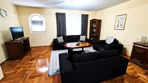 una sala de estar con un sofá y una mesa en Villa Zlatan Poolside, en Bosanska Gradiška