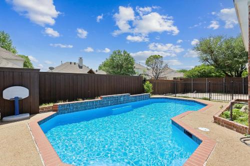 a swimming pool in a backyard with a fence at Family Fun Retreat- Pool & Entertainment Haven! home in Frisco