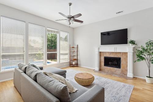 a living room with a couch and a fireplace at Family Fun Retreat- Pool & Entertainment Haven! home in Frisco