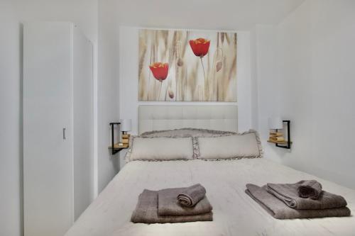 a bedroom with a bed with towels on it at Vanili Santa Pola in Santa Pola