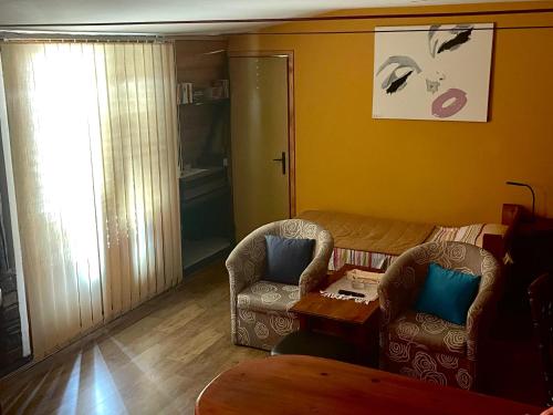 a living room with two chairs and a table at Apartment Jancic in Smederevo