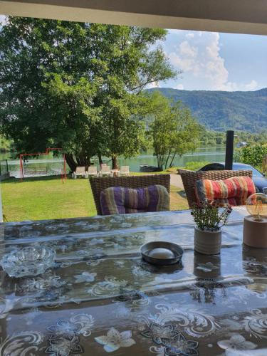 a table with chairs and a view of a field at Vikendica Marija, Culine in Mali Zvornik