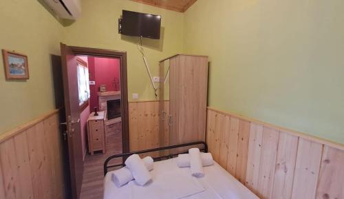 a room with a bed and a tv on the wall at Homico 1 Lefokastro in Lefokastro