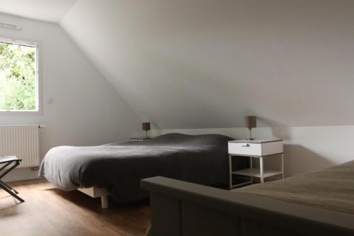 a bedroom with two beds and a window at La maison de Qui miac in Quimiac