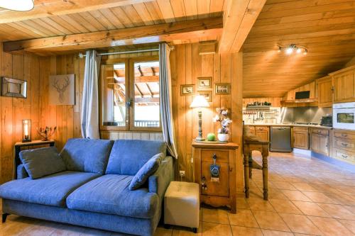 un salon avec un canapé bleu et une cuisine dans l'établissement Chalet Puy-Saint-Pierre avec vue, à Puy-Saint-Pierre