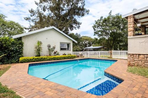 una piscina frente a una casa en Cottage on Keurboom, en Midrand